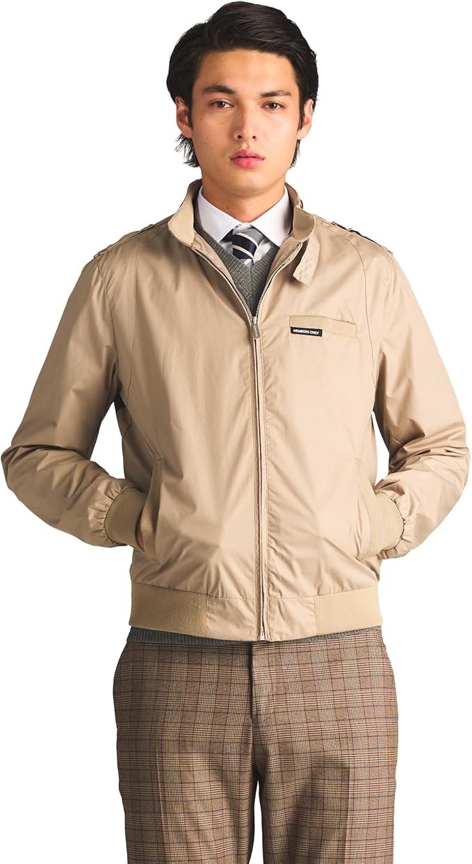 Man wearing a beige jacket over a suit on a white background
