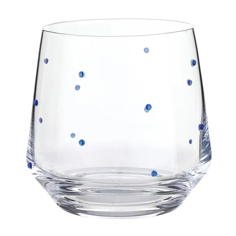Clear glass tumbler with blue dots on a white background