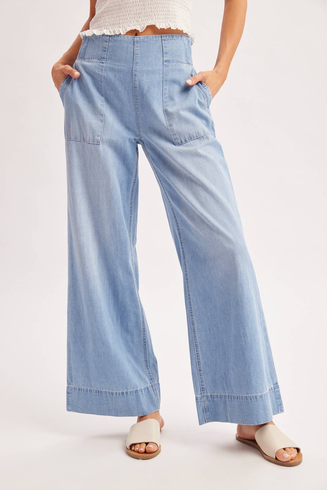 Light blue wide-leg jeans worn by a person on a white background