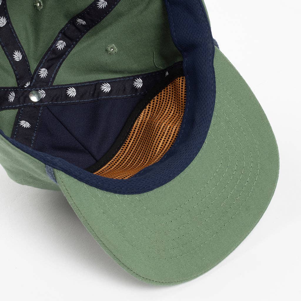 Green cap with navy brim and brown mesh back on a white background