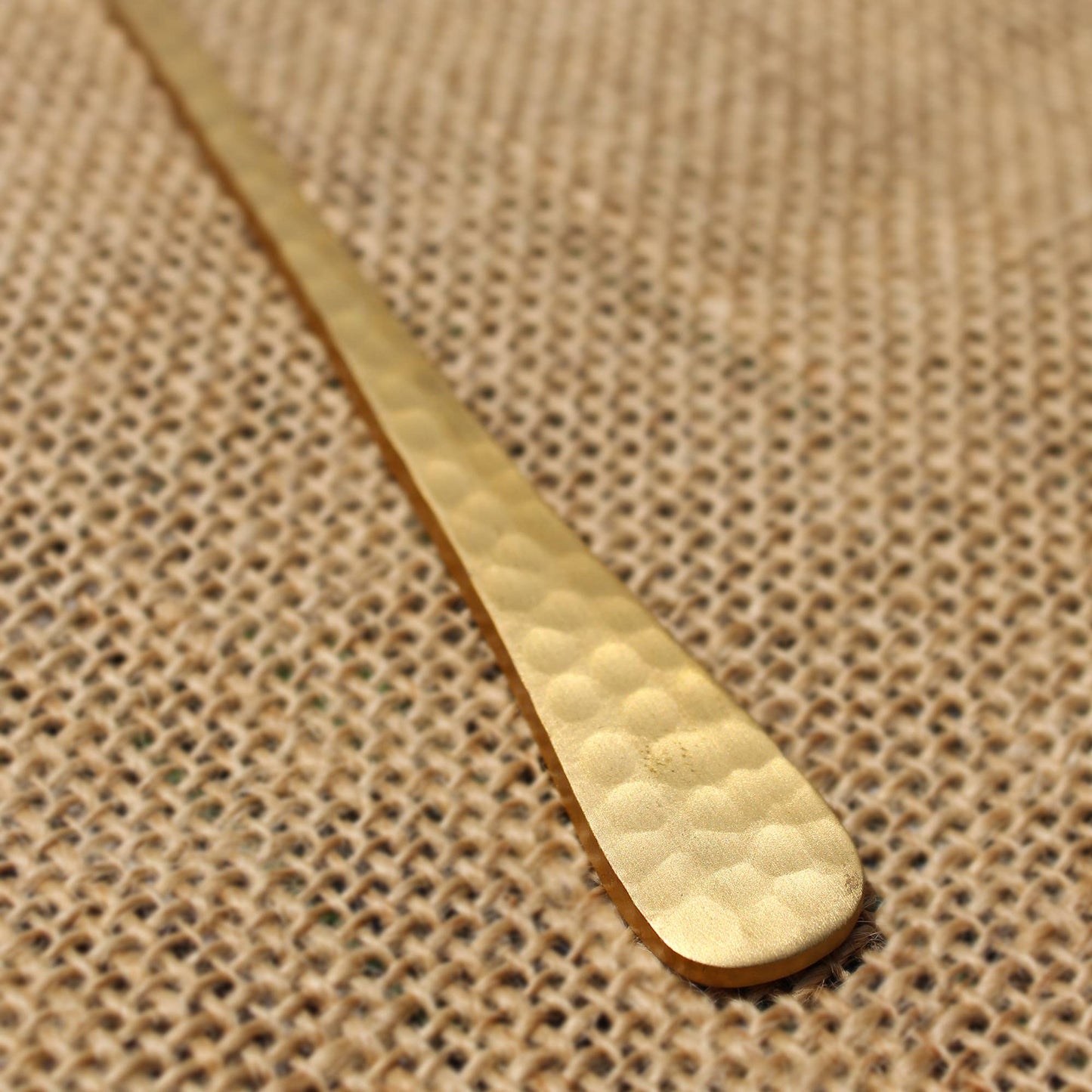 Gold spoon on a textured brown fabric background