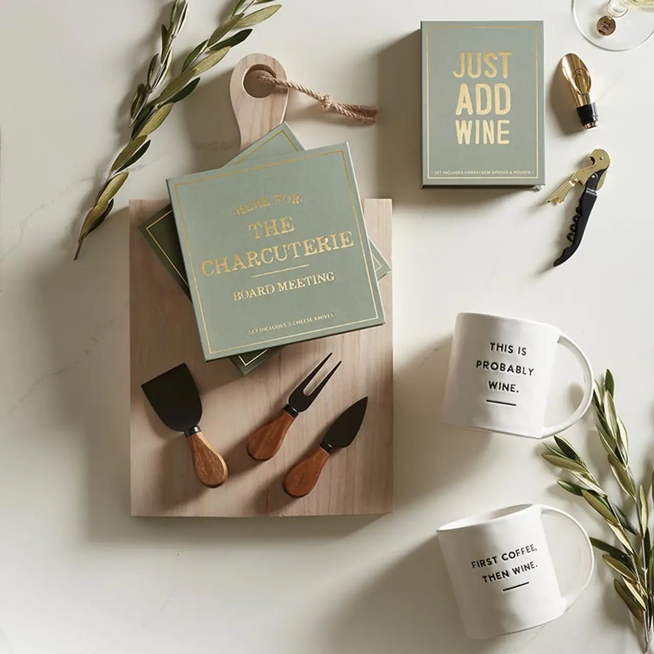 Table setting with charcuterie board, wine-themed cards, and mugs 