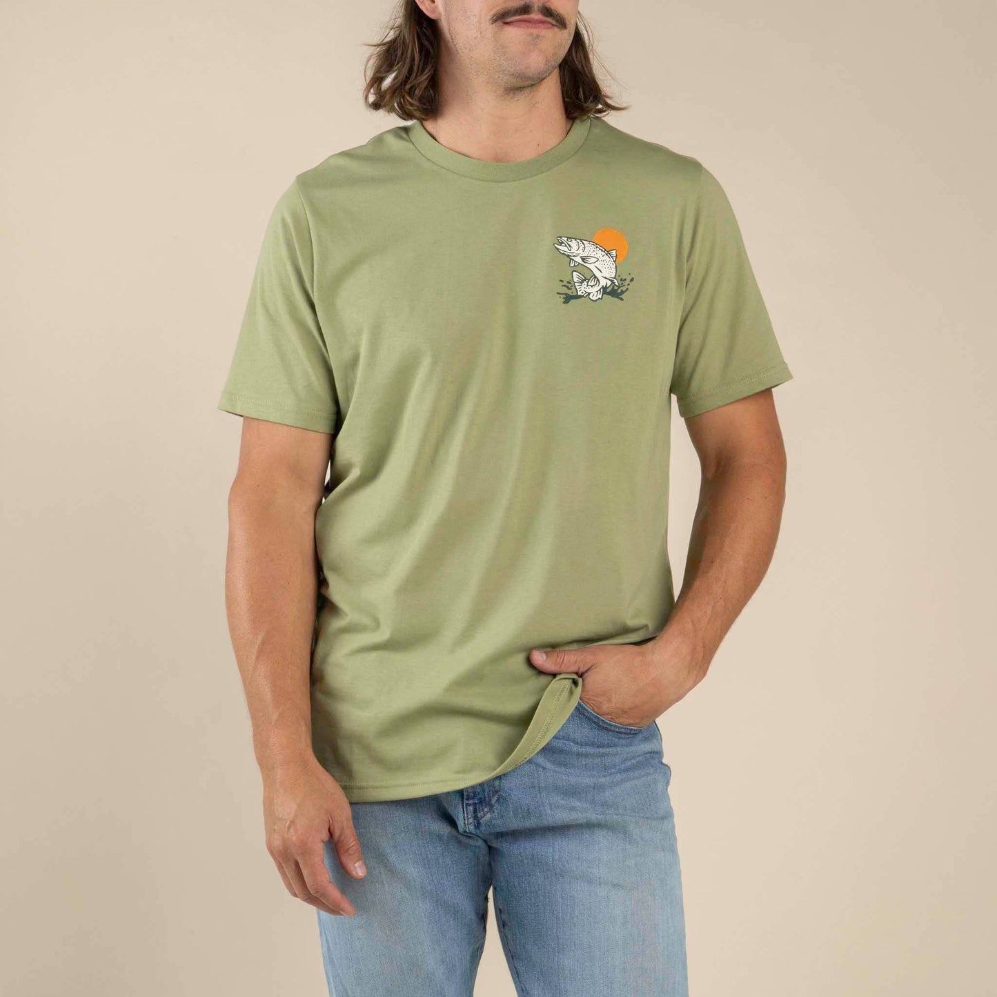 Person wearing a green t-shirt with a graphic design on a beige background