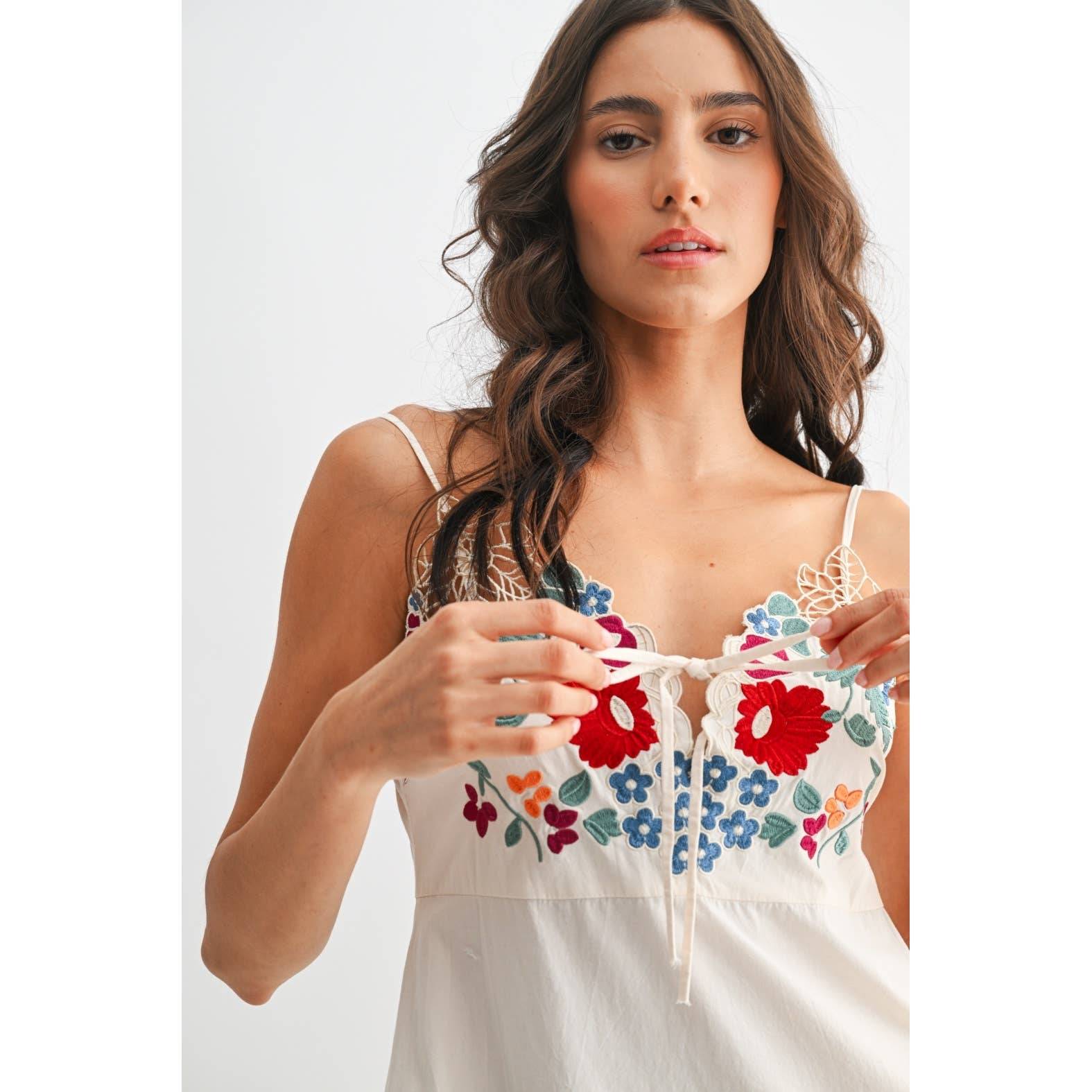 Woman wearing a white dress with colorful floral embroidery 