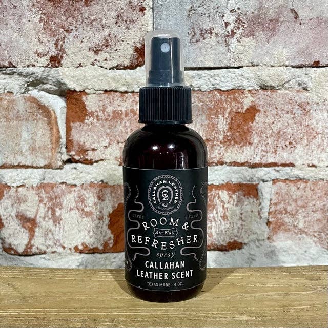 Bottle of Callahan Leather Scent Room & Refresher spray against a brick wall.