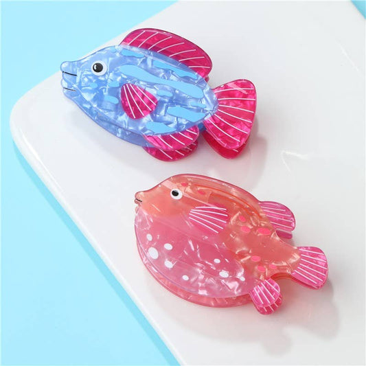 Two colorful fish-shaped objects on a white surface with a light blue background