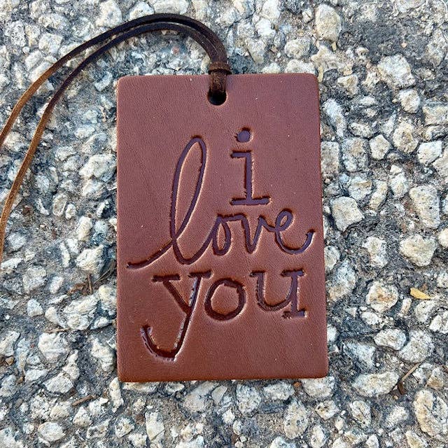 Brown rectangular pendant with 'i love you' engraving on a textured surface