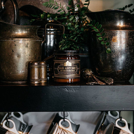 candle that says san antonio on a shelf