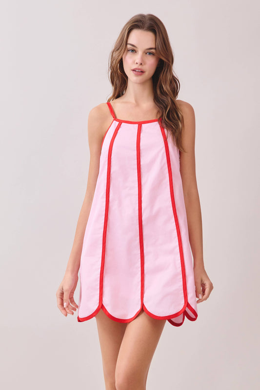 Woman wearing a pink dress with red trim 