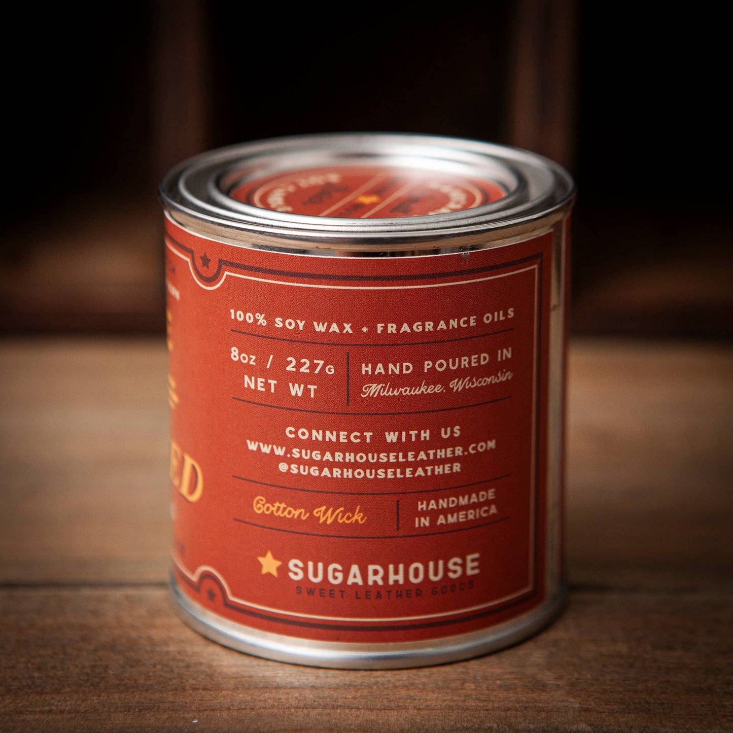 Candle can with red label on a wooden surface