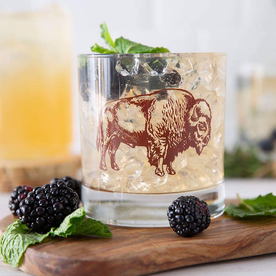 bison on a rocks glass with liquid and blackberries
