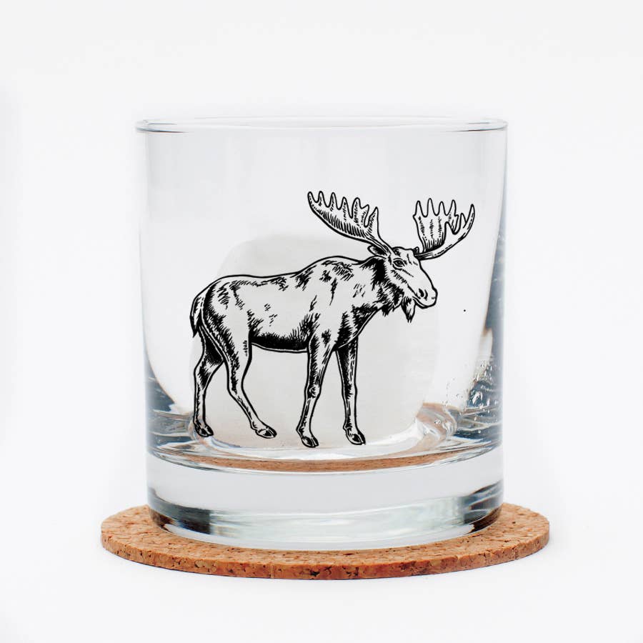 Clear glass tumbler with a moose illustration on a cork coaster