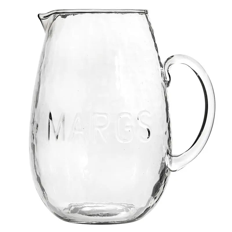 Clear glass pitcher with 'Margs' engraving on a white background