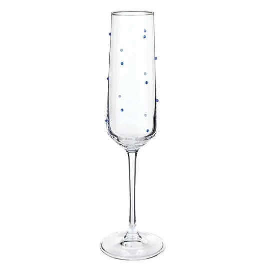 Clear champagne flute with blue polka dots on a white background