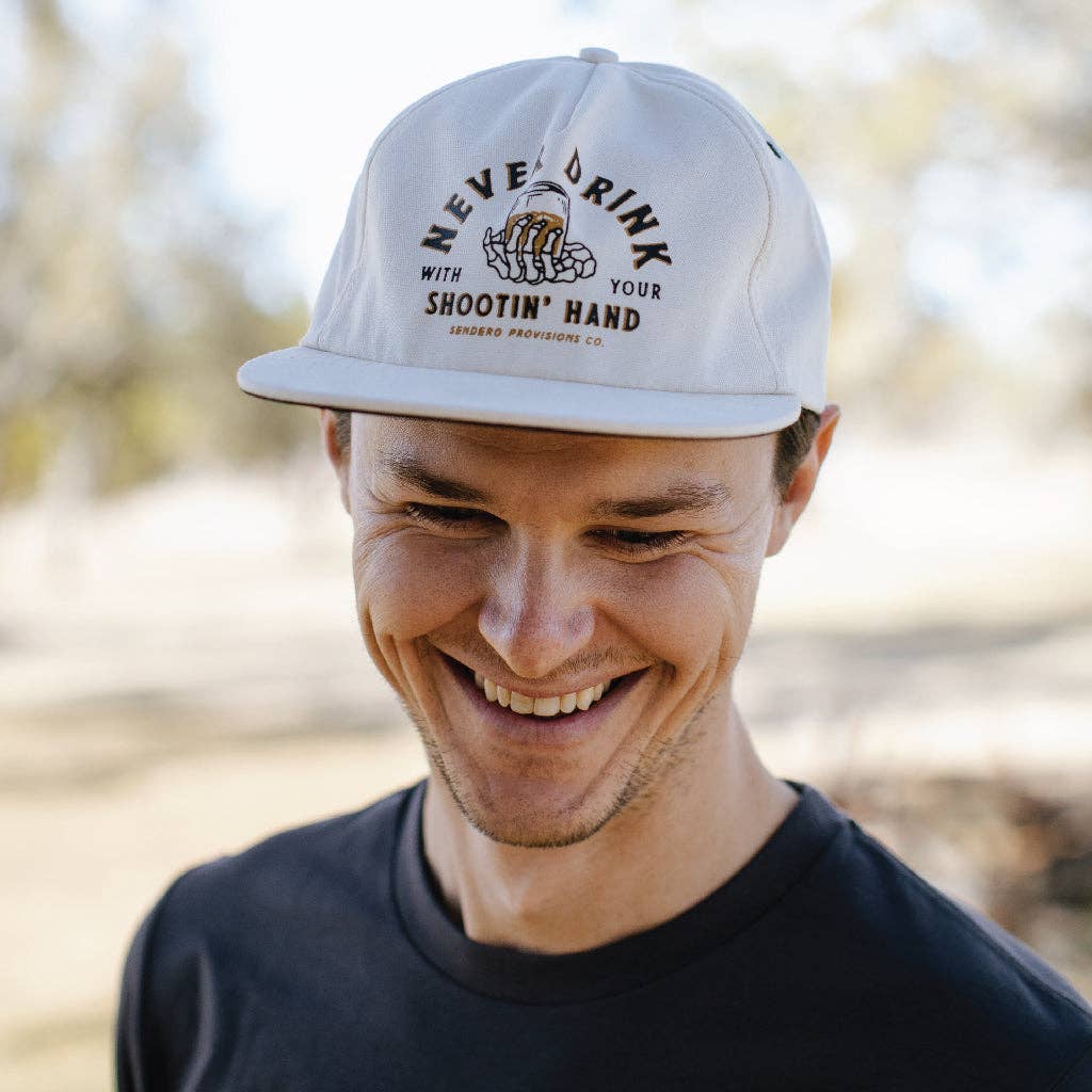 Person wearing a cap with text outdoors