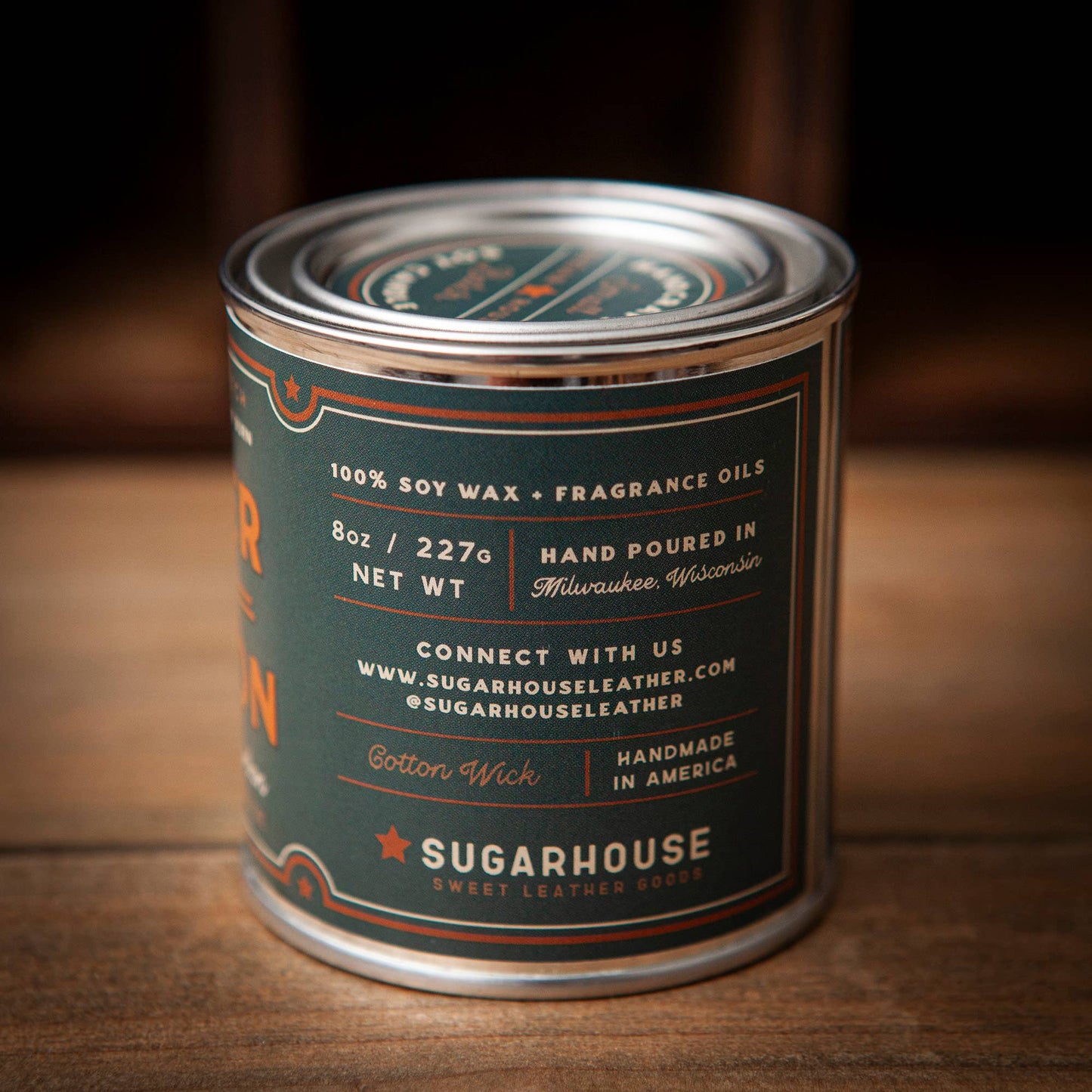 Candle canister with 'Sugarhouse' label on a wooden surface
