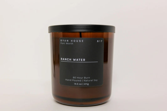 Brown candle with a black label on a white background