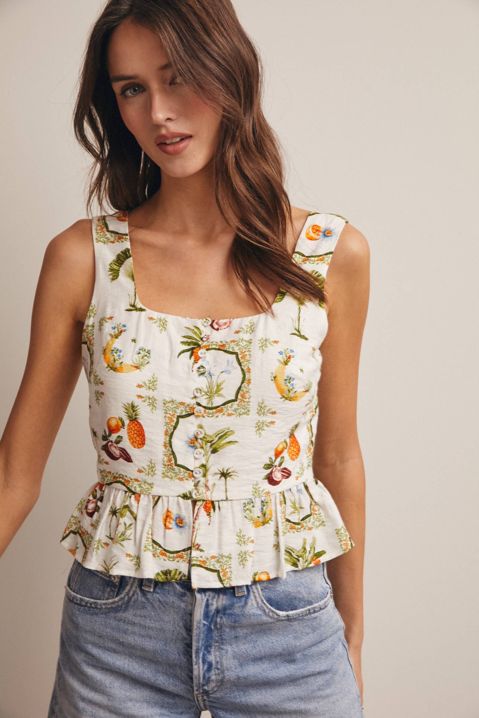 Woman wearing a floral sleeveless top and jeans 