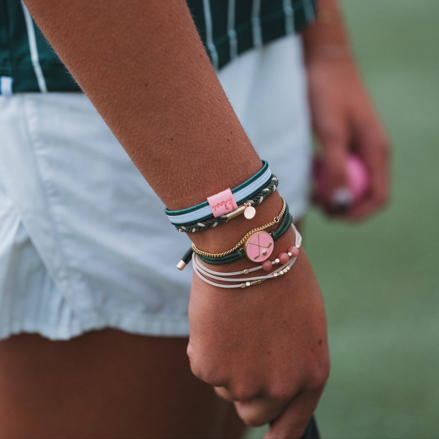 Person wearing multiple bracelets on a blurred background