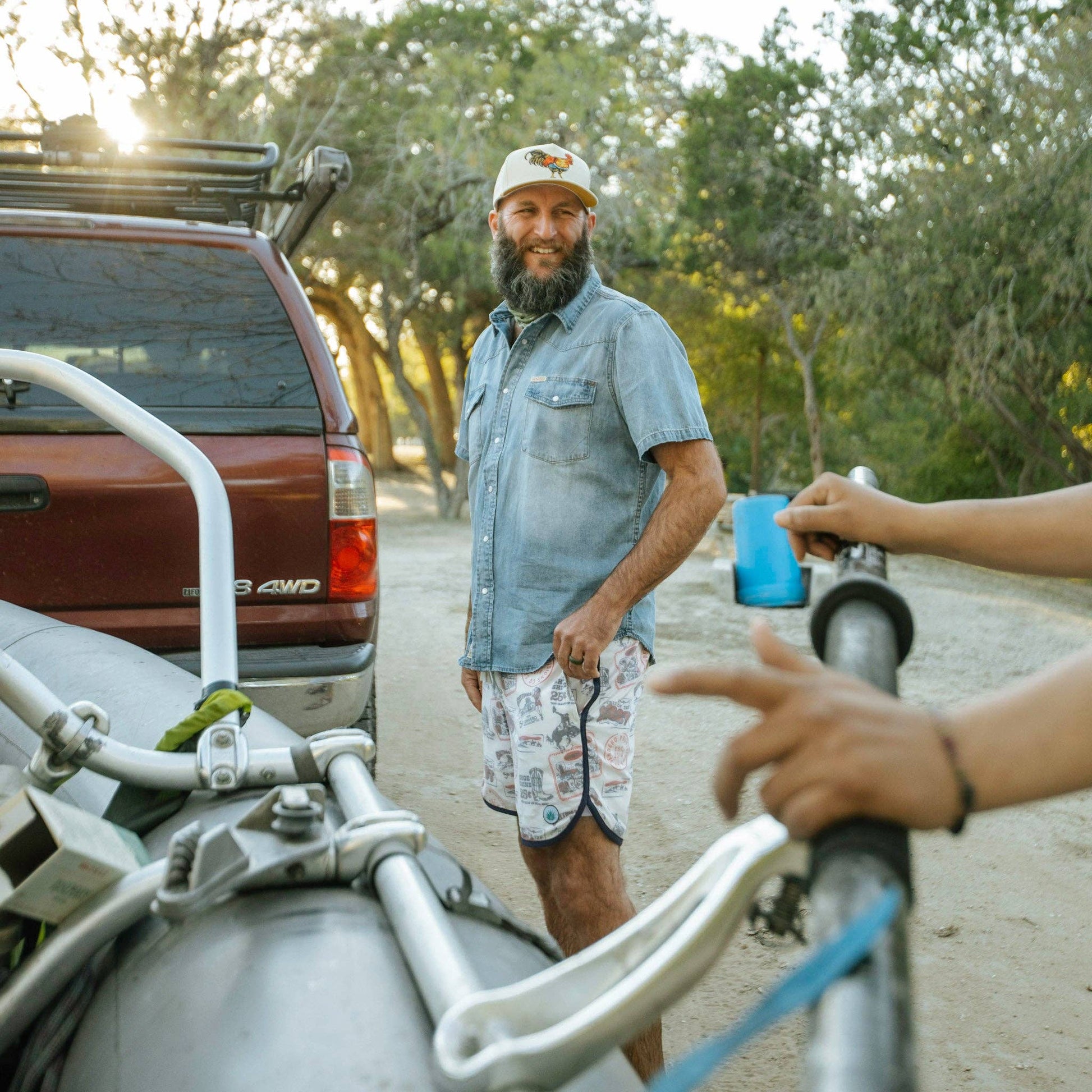 Man standing next to a vehicle wearing a Sendero Yardbird Snapback Hat 