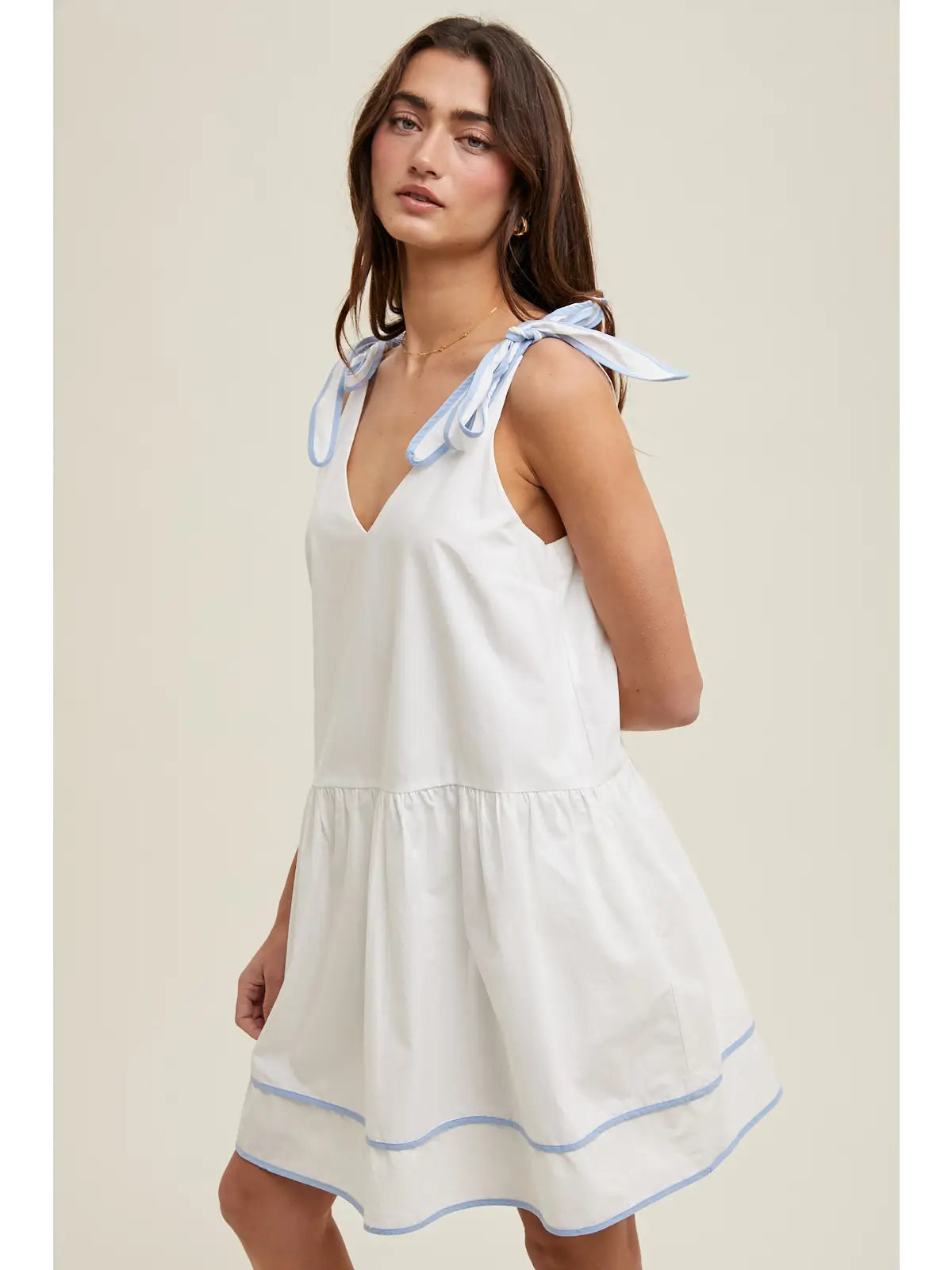 Woman wearing a white dress with blue accents 