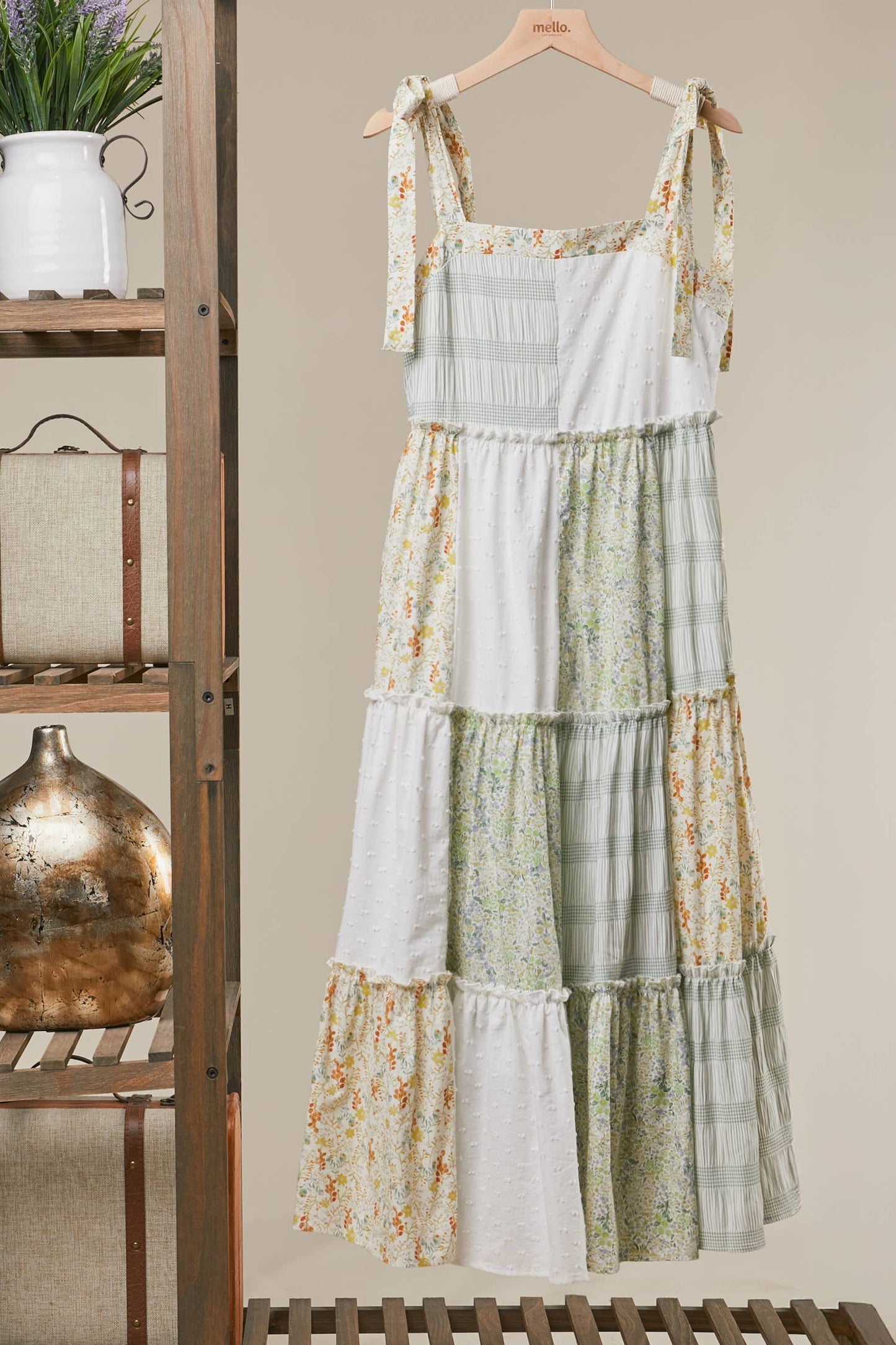Floral tiered dress hanging on a wooden rack with a neutral background