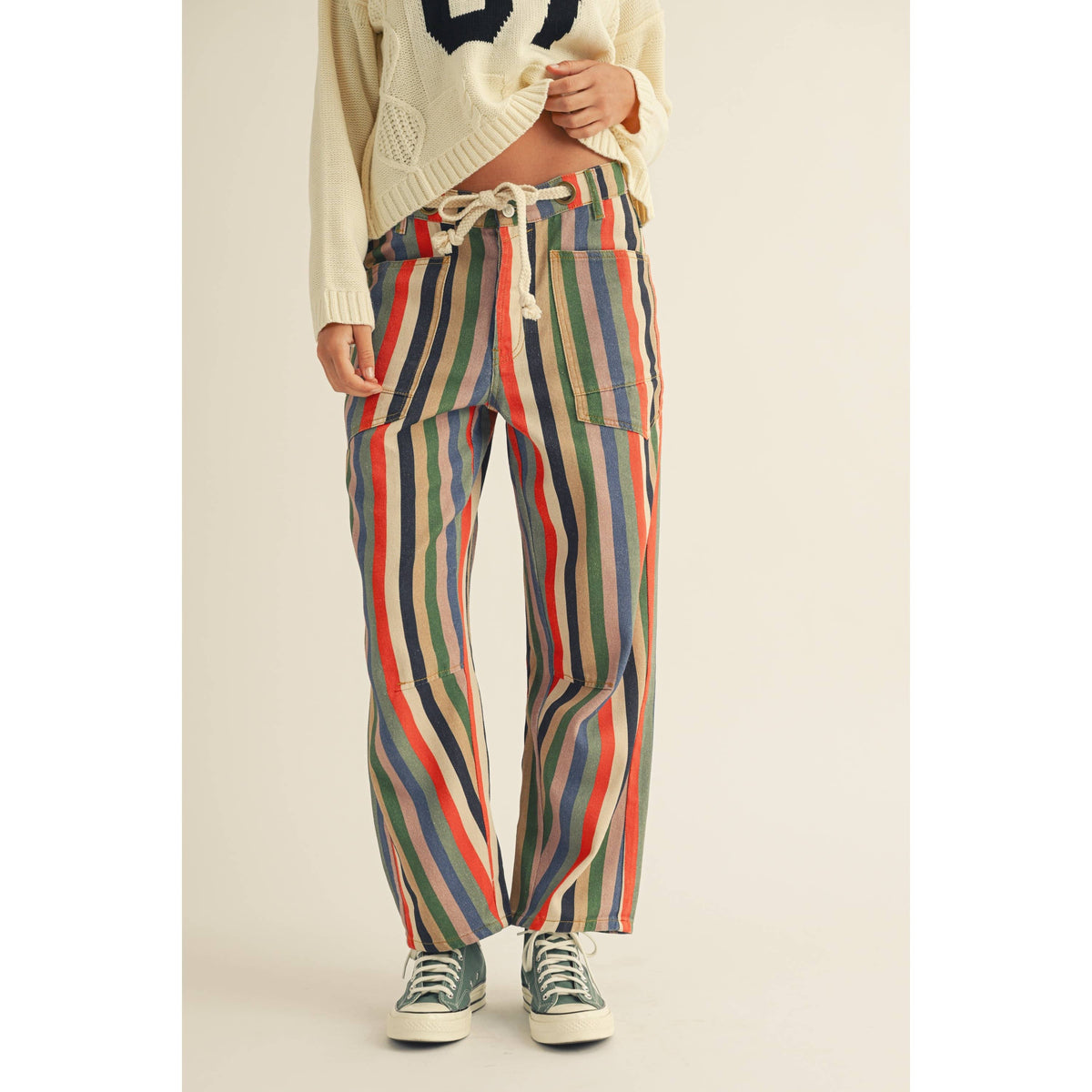 Person wearing colorful striped pants on a plain background