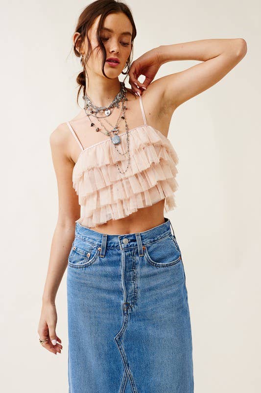 Woman wearing a layered ruffle top and blue jeans