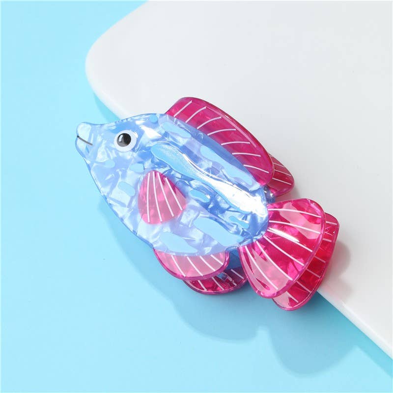 Transparent fish-shaped object with pink fins on a light blue background