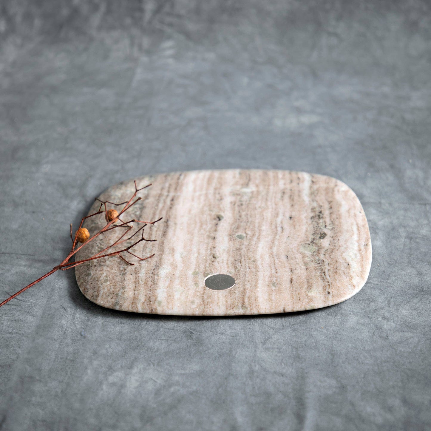 Marble cutting board with a small round hole on a gray background