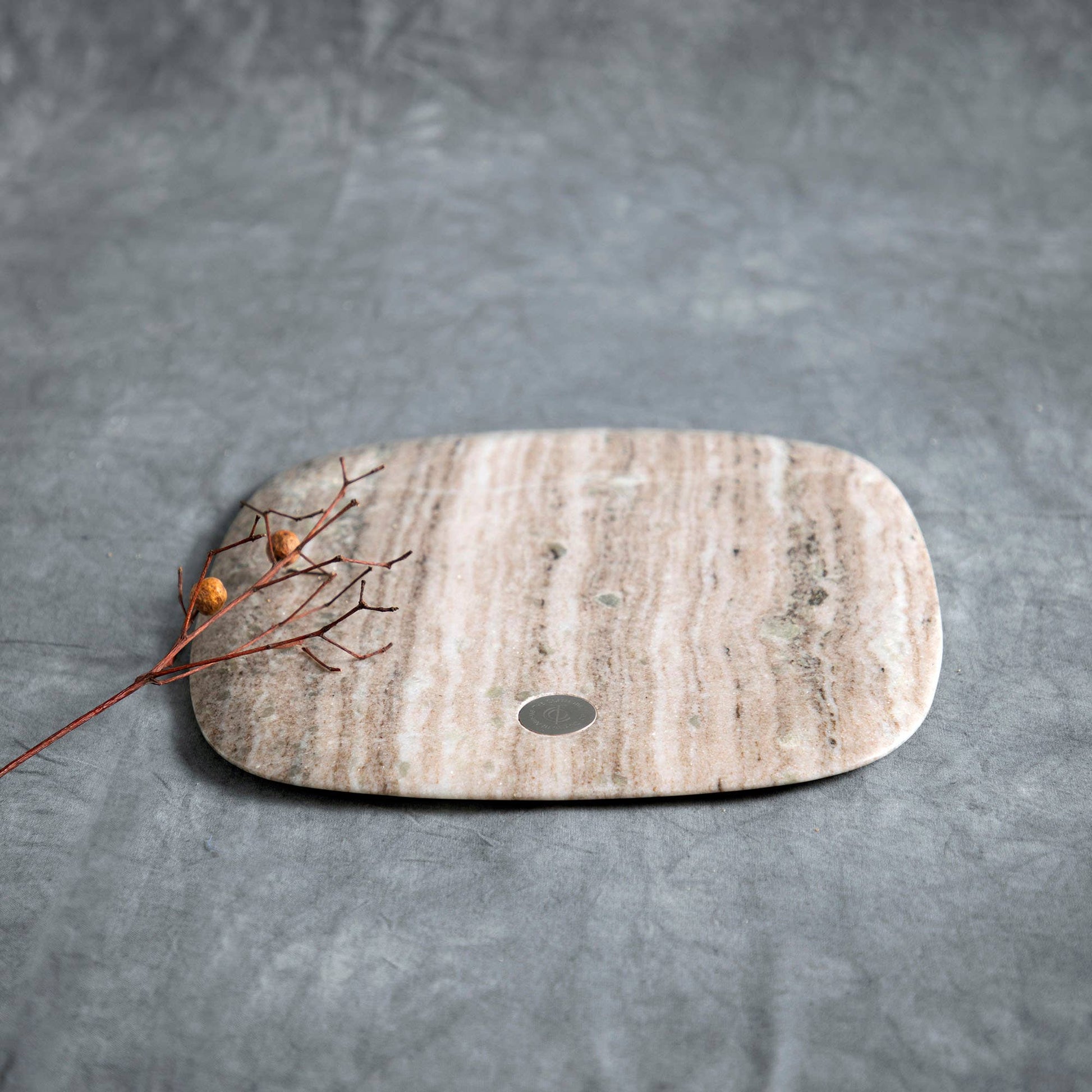 Marble cutting board with a small round hole on a gray background