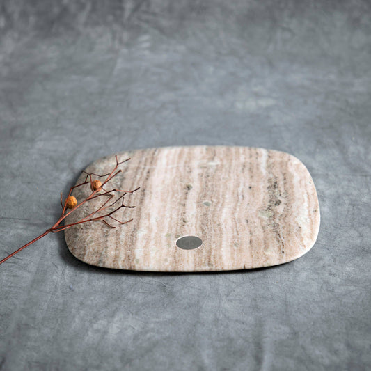 Marble cutting board with a small round hole on a gray background