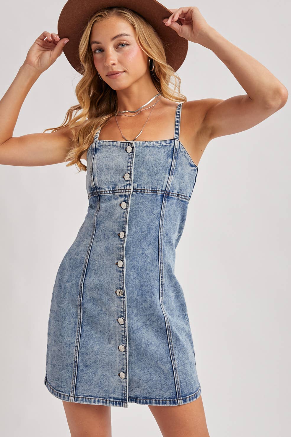 Woman wearing a denim dress and brown hat 